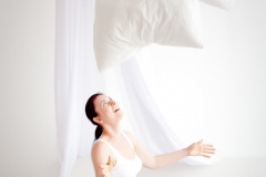young pregnant woman are throwing pillows in the bedroom