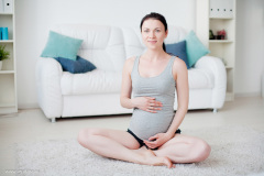 Young pregnant woman do yoga indoors