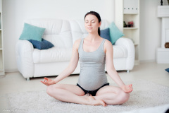 Young pregnant woman do yoga indoors